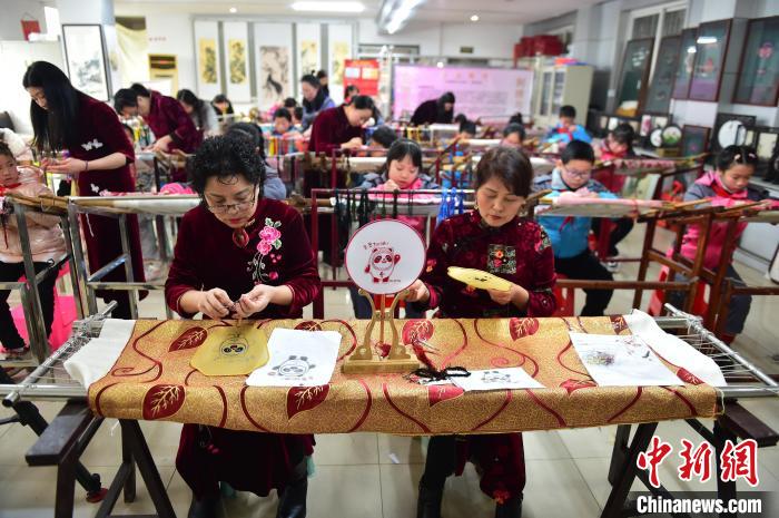 江西省級(jí)非遺豫章繡傳承人手把手指導(dǎo)小學(xué)生繡制2022年北京冬奧會(huì)吉祥物“冰墩墩”形象?！∮髟屏?攝