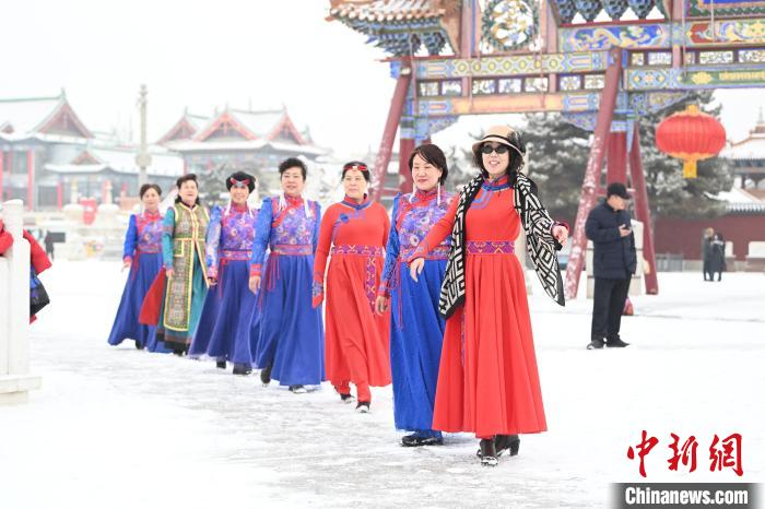 2月13日，老年人在呼和浩特市大召?gòu)V場(chǎng)拍照“打卡”?！⑽娜A 攝