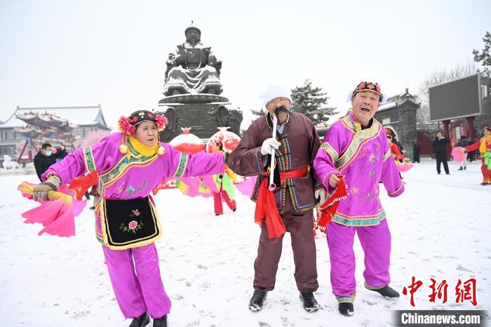 2月13日，秧歌隊(duì)在呼和浩特市大召?gòu)V場(chǎng)雪中起舞?！⑽娜A 攝