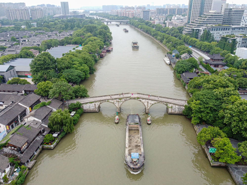 5月27日，一艘貨船駛過京杭大運(yùn)河南端標(biāo)志建筑杭州拱宸橋。(無人機(jī)照片)新華社記者江漢 攝
