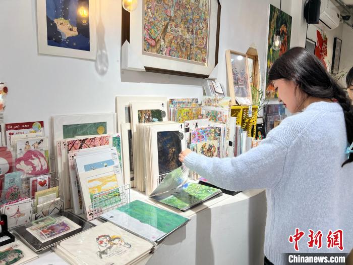 圖為藝術(shù)品商店內(nèi)，顧客挑選插畫(huà)作品。　鐘旖 攝