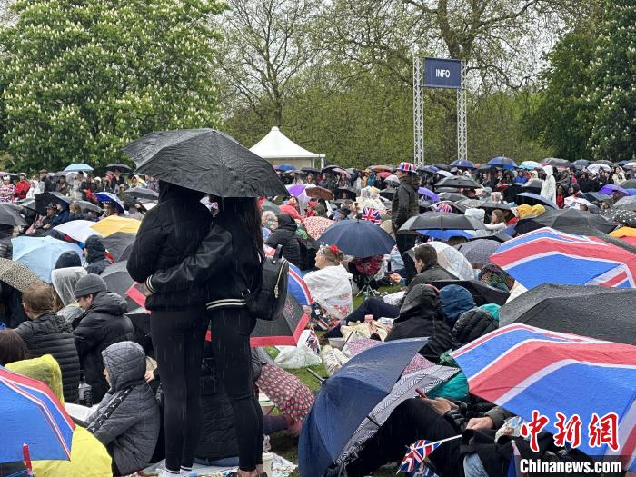 當(dāng)?shù)貢r間5月6日，英國國王查爾斯三世的加冕儀式舉行。民眾雨中觀看儀式。　歐陽開宇 攝