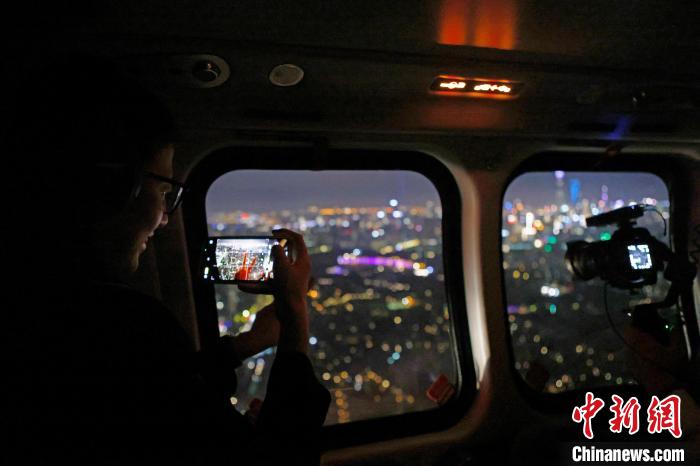 6月3日晚，游客乘坐上海新空直升機(jī)有限公司直升機(jī)開(kāi)啟鳥(niǎo)瞰黃浦江空中圓夢(mèng)之旅，并用手機(jī)拍攝城市夜景?！∫罅⑶?攝