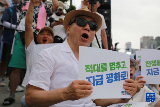 7月22日，在韓國首爾，人們手舉標語參與反戰(zhàn)游行。新華社發(fā)（楊暢 攝）