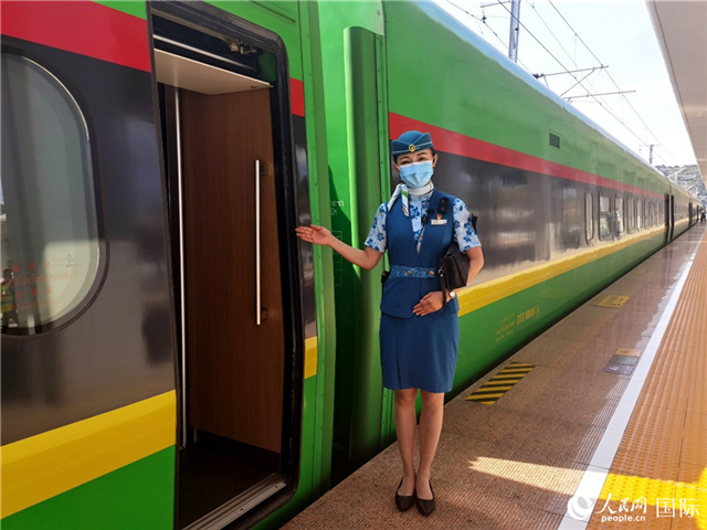 趙瑩靜站在“復興號”國際旅客列車車廂門口歡迎旅客上車。人民網 杜明明攝