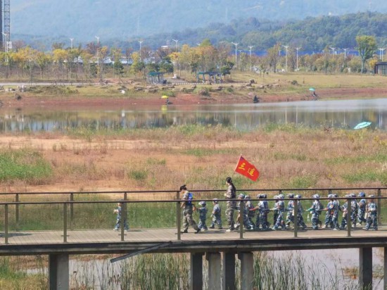 　　10月24日，秋游的幼兒園小朋友在老師帶領(lǐng)下走在清水塘公園里的木橋上。本報(bào)記者 常雯宜攝