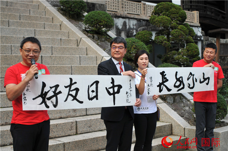 東京中國文化中心主任羅玉泉展示其為本次活動書寫的題詞“中日友好，山高水長”。人民網(wǎng) 蔣曉辰攝