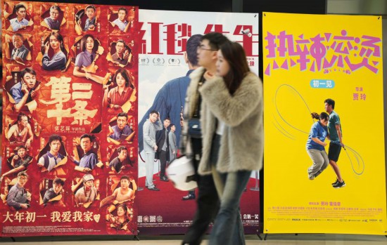 這是2月17日，在沈陽一家影院，觀眾從海報前經(jīng)過。新華社記者李鋼攝