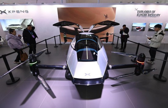 2023年12月1日，在鏈博會智能汽車鏈展區(qū)小鵬汽車展臺，參觀者觀看一臺智能飛行器。新華社記者蔡湘鑫攝