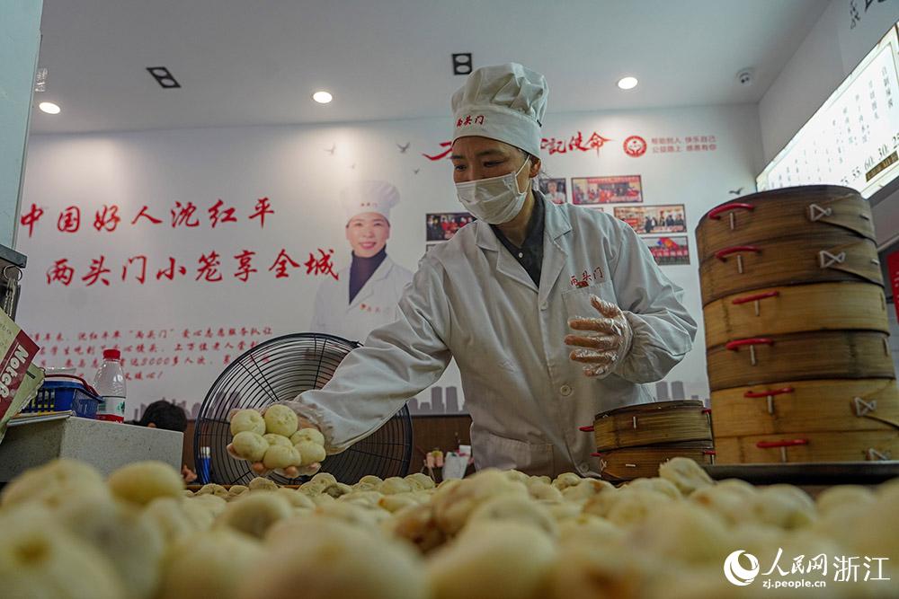 3月31日，在浙江省嵊州市甘霖鎮(zhèn)，嵊州小吃從業(yè)者沈紅平把蒸熟的小籠包晾涼，打包冷藏售賣。人民網(wǎng) 章勇濤攝