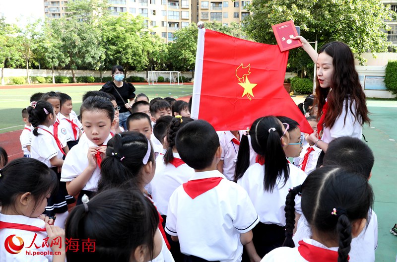 老師向少先隊(duì)員展示隊(duì)旗。人民網(wǎng) 符武平攝