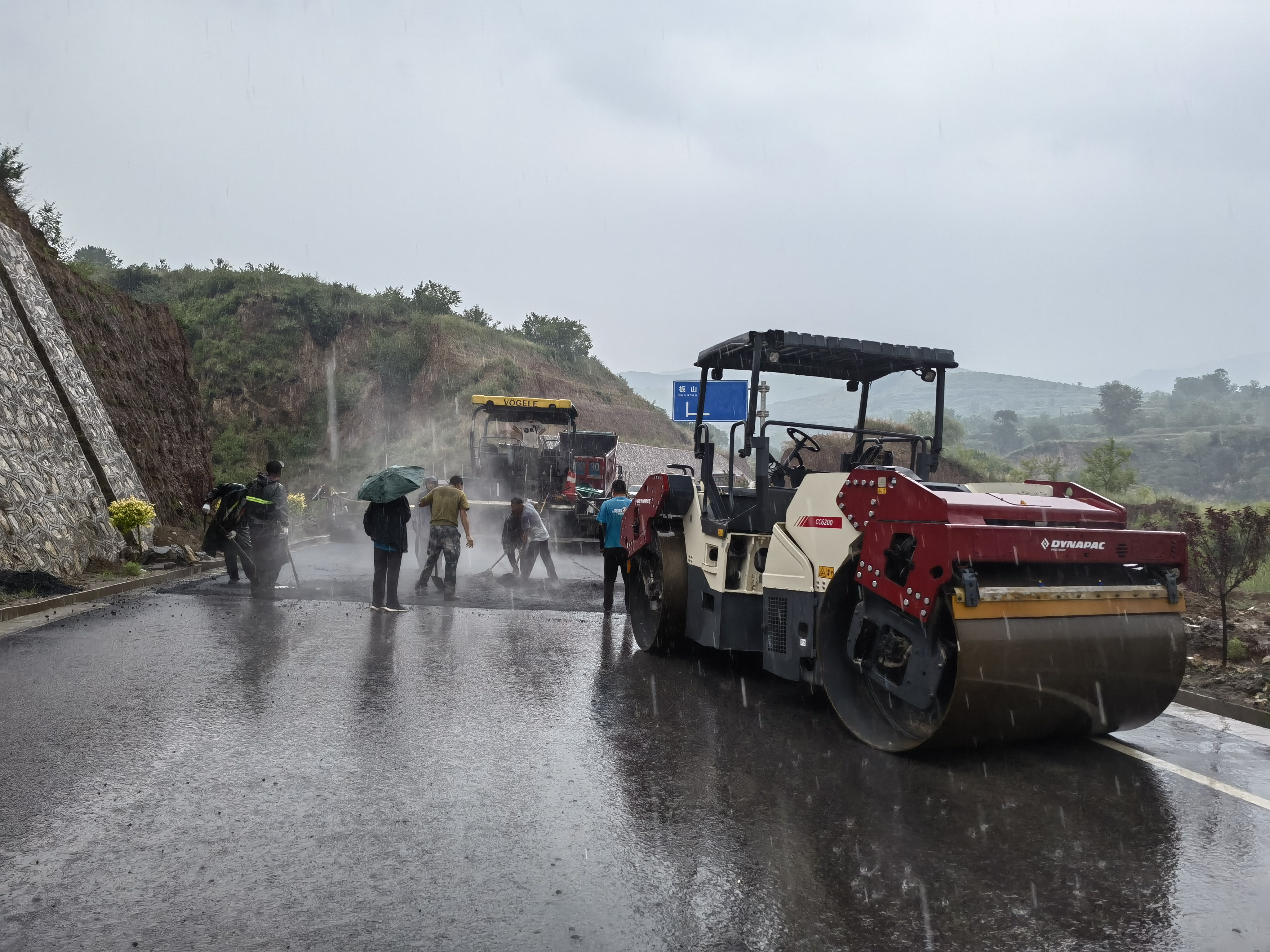 路橋工人在大雨中搶修道路。李華英 攝