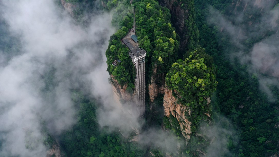 位于張家界武陵源景區(qū)的百龍?zhí)焯蓁偳对谠旗F繚繞的峰林間，雄偉壯觀。吳勇兵攝