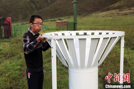 圖為班瑪縣氣象局工作人員在維護(hù)藏雪茶基地氣候站。青海省氣象局供圖