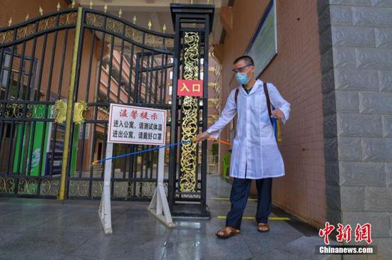 資料圖：?？诮?jīng)濟學院的工作人員在學生宿舍樓入口消毒。 中新社記者 駱云飛 攝