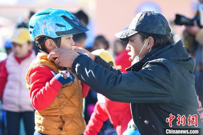 圖為拉薩市實驗幼兒園孩子在教練的幫助下穿戴頭盔。　何蓬磊 攝