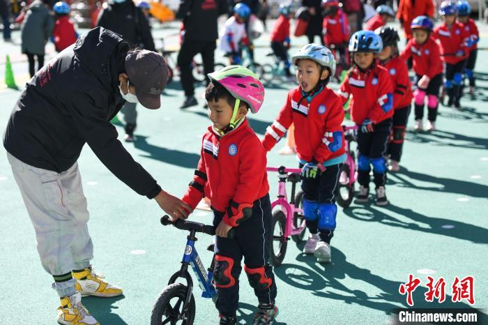 圖為拉薩市實驗幼兒園孩子們在教練的指導(dǎo)下練習(xí)滑步車?！『闻罾?攝