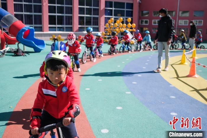 圖為拉薩市實驗幼兒園孩子們在教練的指導(dǎo)下練習(xí)滑步車?！『闻罾?攝