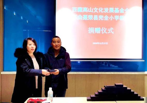 圖為西藏高山文化發(fā)展基金會(huì)理事長(zhǎng)溫麗向聶榮縣完全小學(xué)負(fù)責(zé)人捐助儀器?！∮谫e 攝