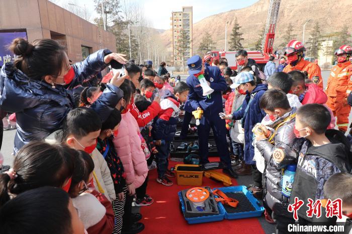 圖為小朋友們聽消防員講解消防器材。　楊龍建 攝