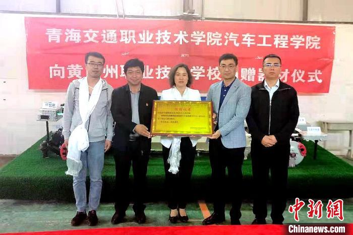 圖為李富香(中)代表學(xué)校為州縣技校捐贈(zèng)器材。(資料圖) 青海省教育廳供圖