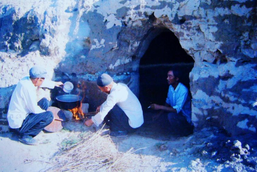 1983年，“六老漢”一代治沙人在“地窩子”生活做飯。新華社發(fā)（八步沙林場供圖）