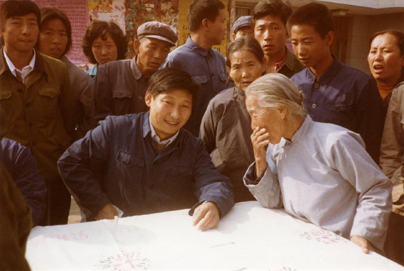 1983年，時(shí)任河北正定縣委書記的習(xí)近平（前排居中），臨時(shí)在大街上擺桌子聽取老百姓意見。