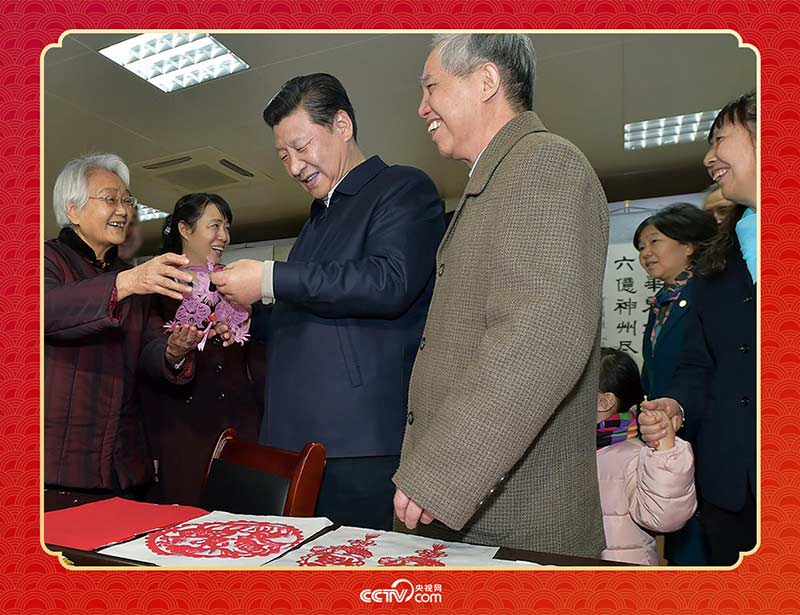 2015年2月15日，習近平在西安市雁塔區(qū)電子城街道二〇五所社區(qū)服務中心欣賞社區(qū)居民的剪紙作品。
