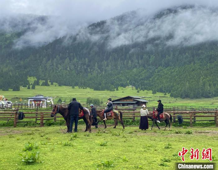 6月10日，游客在魯朗小鎮(zhèn)高山牧場景區(qū)體驗騎馬?！∪轿木?攝