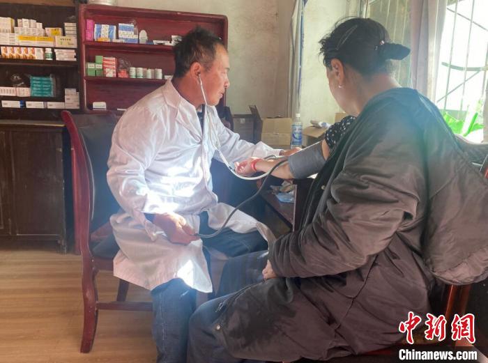 索木滾(左)為村民看病?！∪捞量h委宣傳部供圖