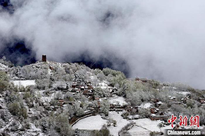 雪后的藏寨和碉樓構(gòu)成美麗的雪景?！〗党鯘衫?攝