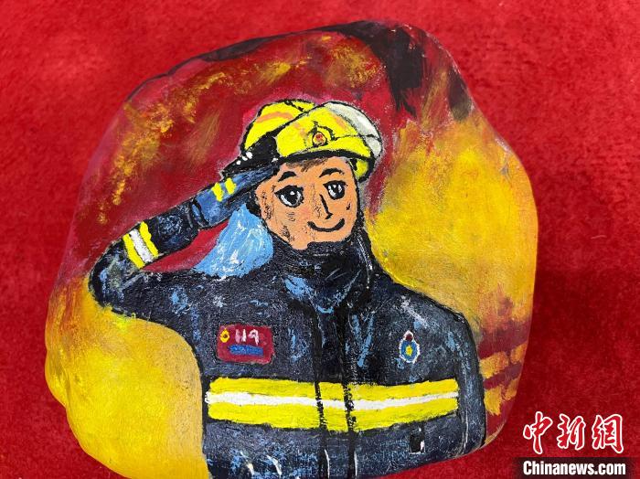 圖為玉樹消防指戰(zhàn)員創(chuàng)作的石頭畫作品《請祖國和人民放心》?！O瑞祥 攝