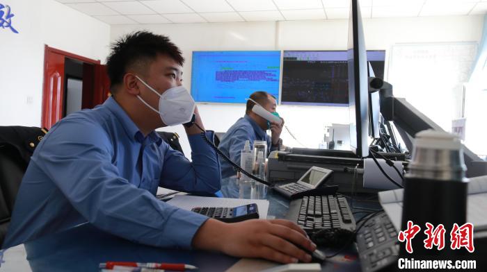 圖為貨運(yùn)調(diào)度人員與外勤工作人員聯(lián)系掌握車(chē)輛裝載情況?！±钌?攝