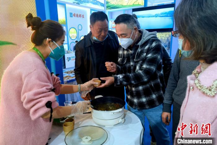 圖為杭州市民品嘗茶卡羊肉?！±铍h 攝