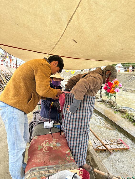扎西奪爾登為路邊老人送去保暖圍腰。阿壩州文明辦供圖