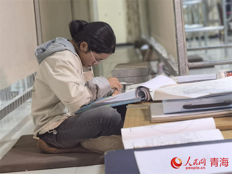 正在學(xué)習(xí)畫(huà)底稿的尕讓旺姆。人民網(wǎng) 陳明菊攝