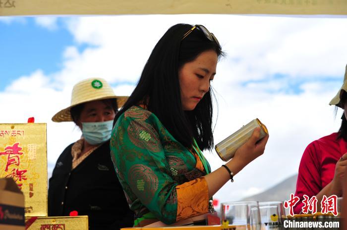 圖為拉薩市民在特色農(nóng)畜產(chǎn)品展示展銷會(huì)上選購商品?！垈?攝