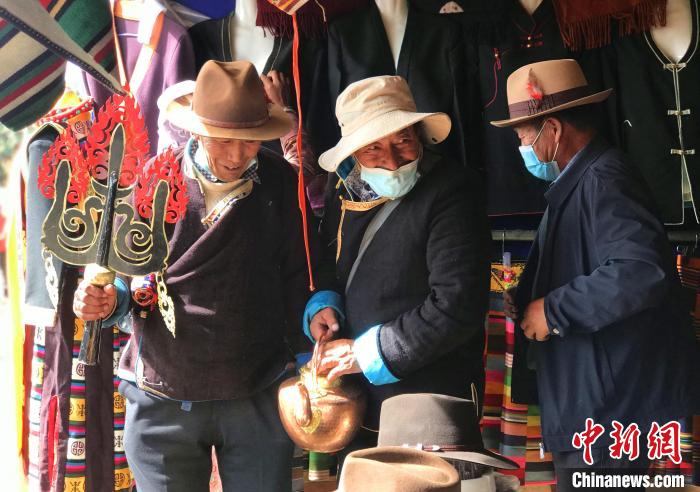 圖為三位藏族老人在集市上聊天交談。　冉文娟 攝