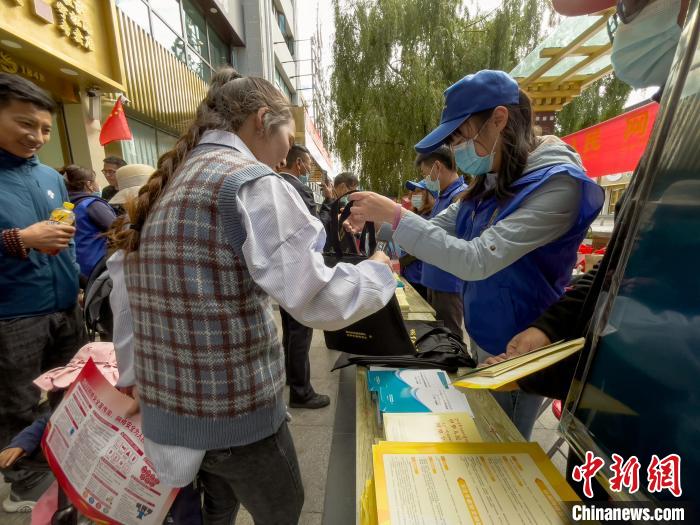 圖為志愿者為市民發(fā)放網(wǎng)絡(luò)安全宣傳手冊(cè)?！≈x牧 攝