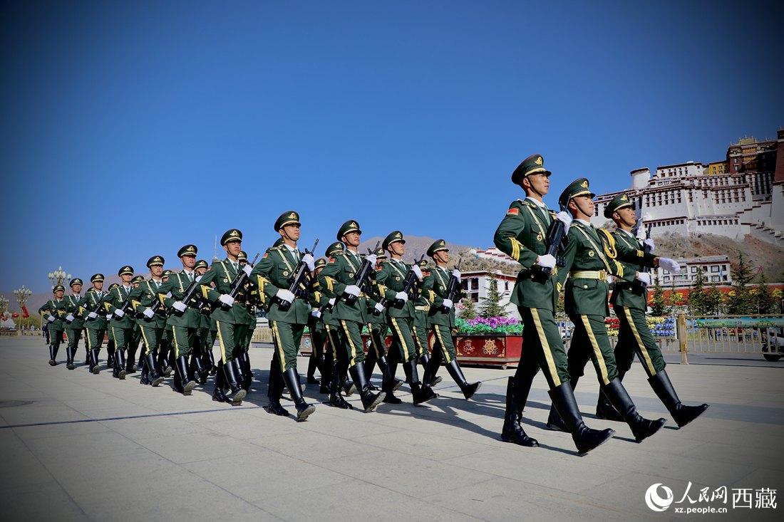 國(guó)旗護(hù)衛(wèi)隊(duì)隊(duì)員緊握鋼槍，踏著威武雄壯的步伐，走向國(guó)旗臺(tái)。人民網(wǎng) 次仁羅布攝