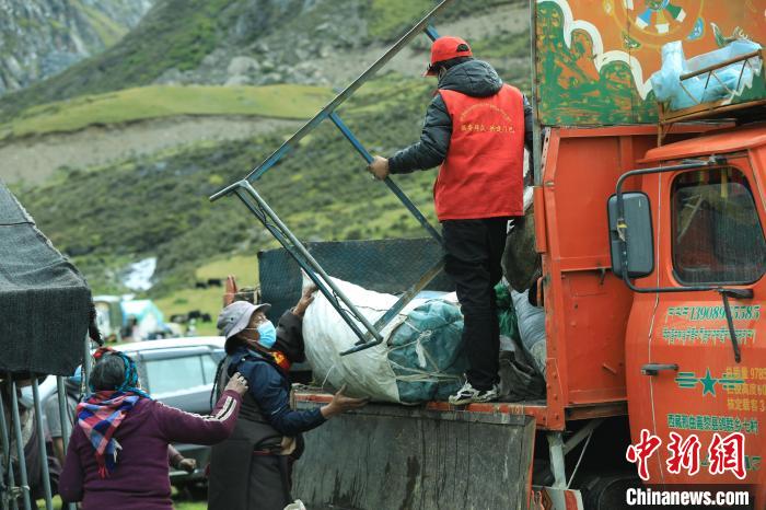 圖為工作人員幫助牧民們卸家具?！÷蹇?攝