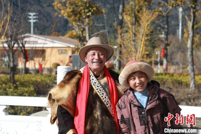 圖為林芝市巴宜區(qū)布久鄉(xiāng)仲果村村民桑杰與孫子一起參加藏歷新年活動?！埩?攝