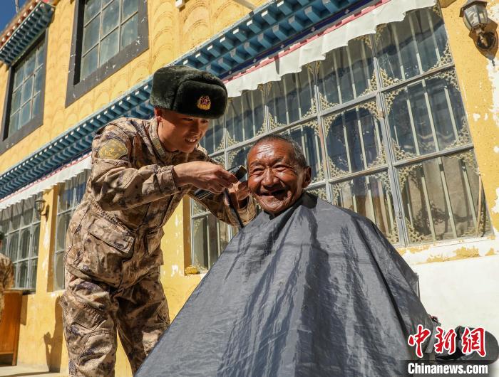 圖為阿里軍分區(qū)某邊防團(tuán)官兵為駐地群眾理發(fā)迎藏歷新年?！〉┰鰝愔?攝