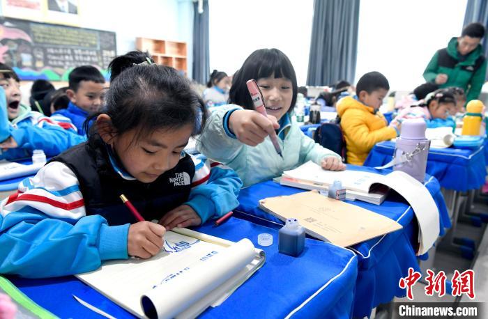 3月14日，西藏拉薩市第一小學(xué)一年級六班學(xué)生白瑪朗珍(圖左)在藏語文課上書寫藏文?！±盍?攝