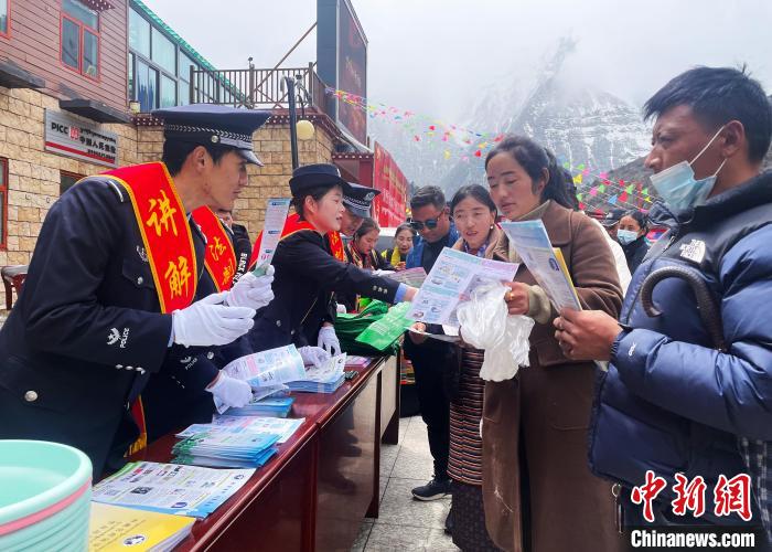 圖為山南玉麥邊境派出所民警為轄區(qū)群眾發(fā)放法律知識(shí)宣傳單?！＄婗?　攝