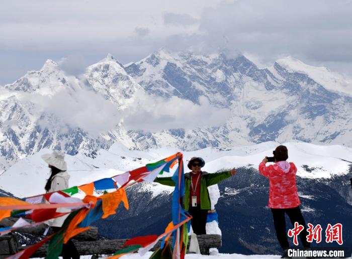 圖為5月14日，西藏林芝色季拉山觀景臺，游客與南迦巴瓦峰合影。　李林 攝