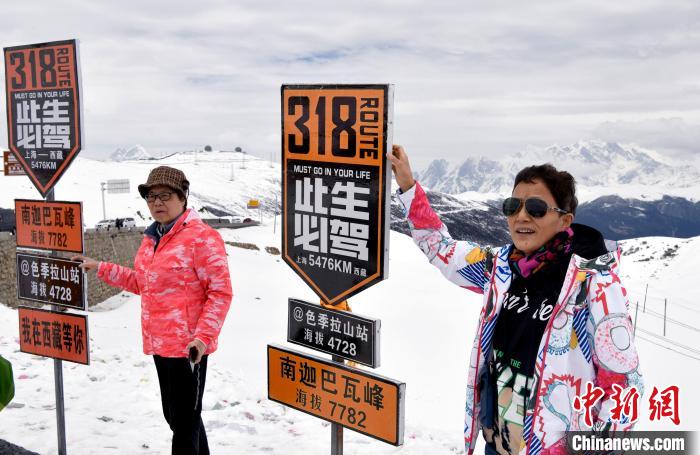 圖為5月14日，西藏林芝色季拉山觀景臺，游客與南迦巴瓦峰合影?！±盍?攝