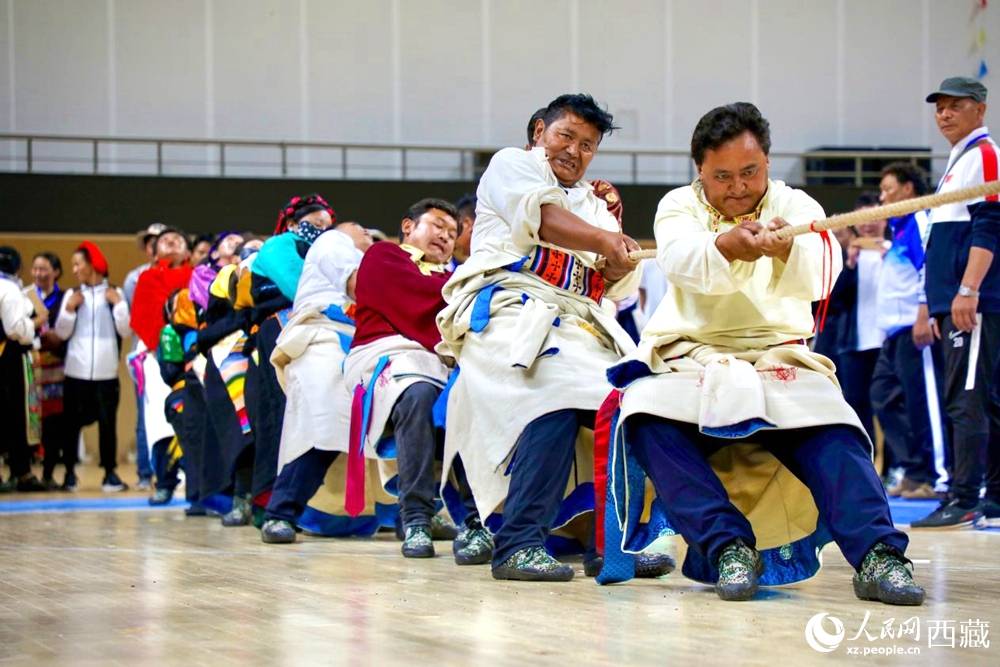 身著民族服裝的農(nóng)牧民選手在拔河比賽現(xiàn)場。