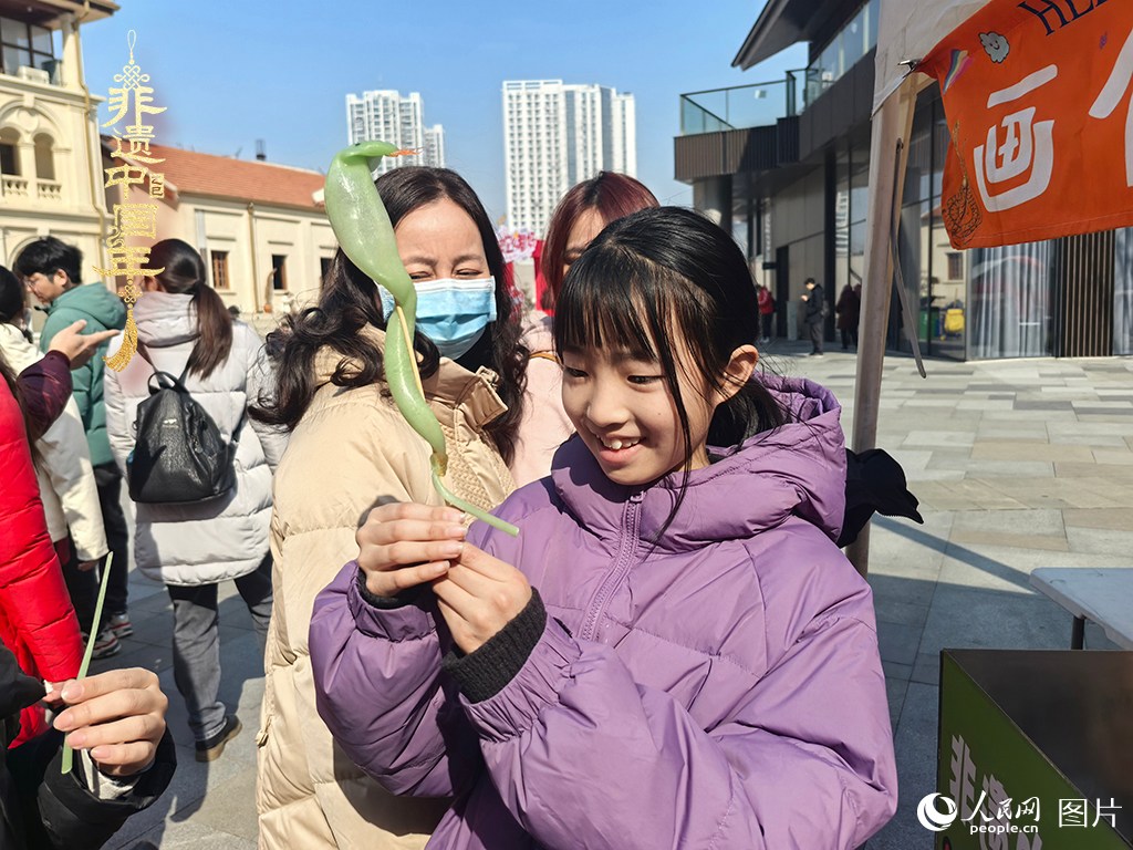 2025年1月29日，湖北武漢的新春廟會(huì)上，小朋友拿著吹制好的糖人，十分開心。人民網(wǎng)記者 張沛攝