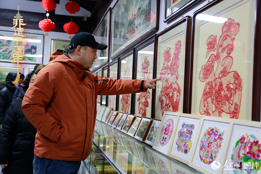 2025年1月23日，游客在天津楊柳青古鎮(zhèn)欣賞傳統(tǒng)剪紙作品，感受指尖上的古老藝術(shù)。人民網(wǎng)記者 崔新耀攝